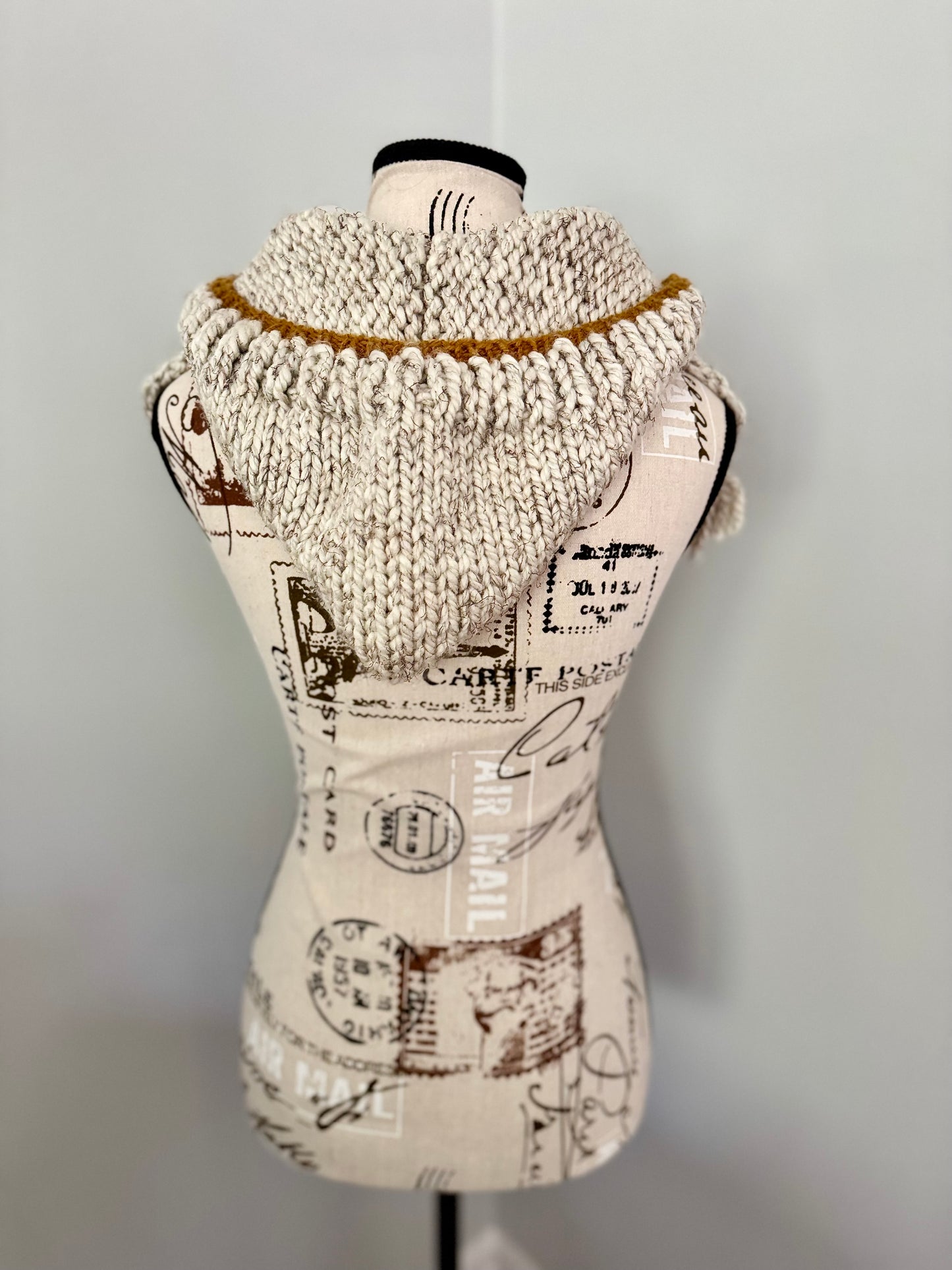 Beige hooded bandana cowl featuring fringe edging and gold accents.