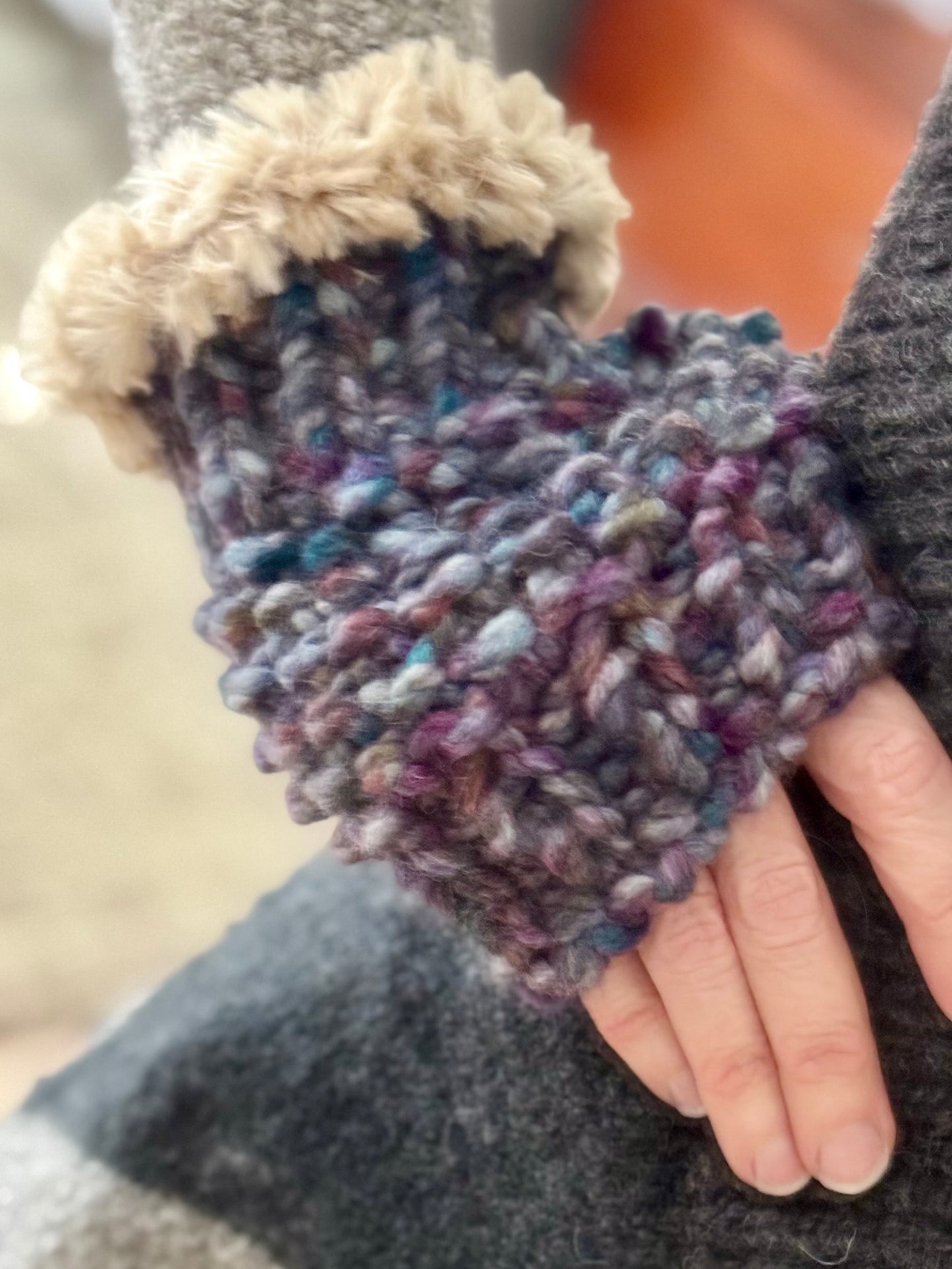 Super bulky seed stitch hand knitted hand warmers featuring faux fur edging at the wrists.