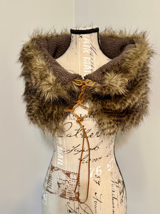 Brown knitted vest with faux fur trim and leather lacing on a mannequin against a plain background