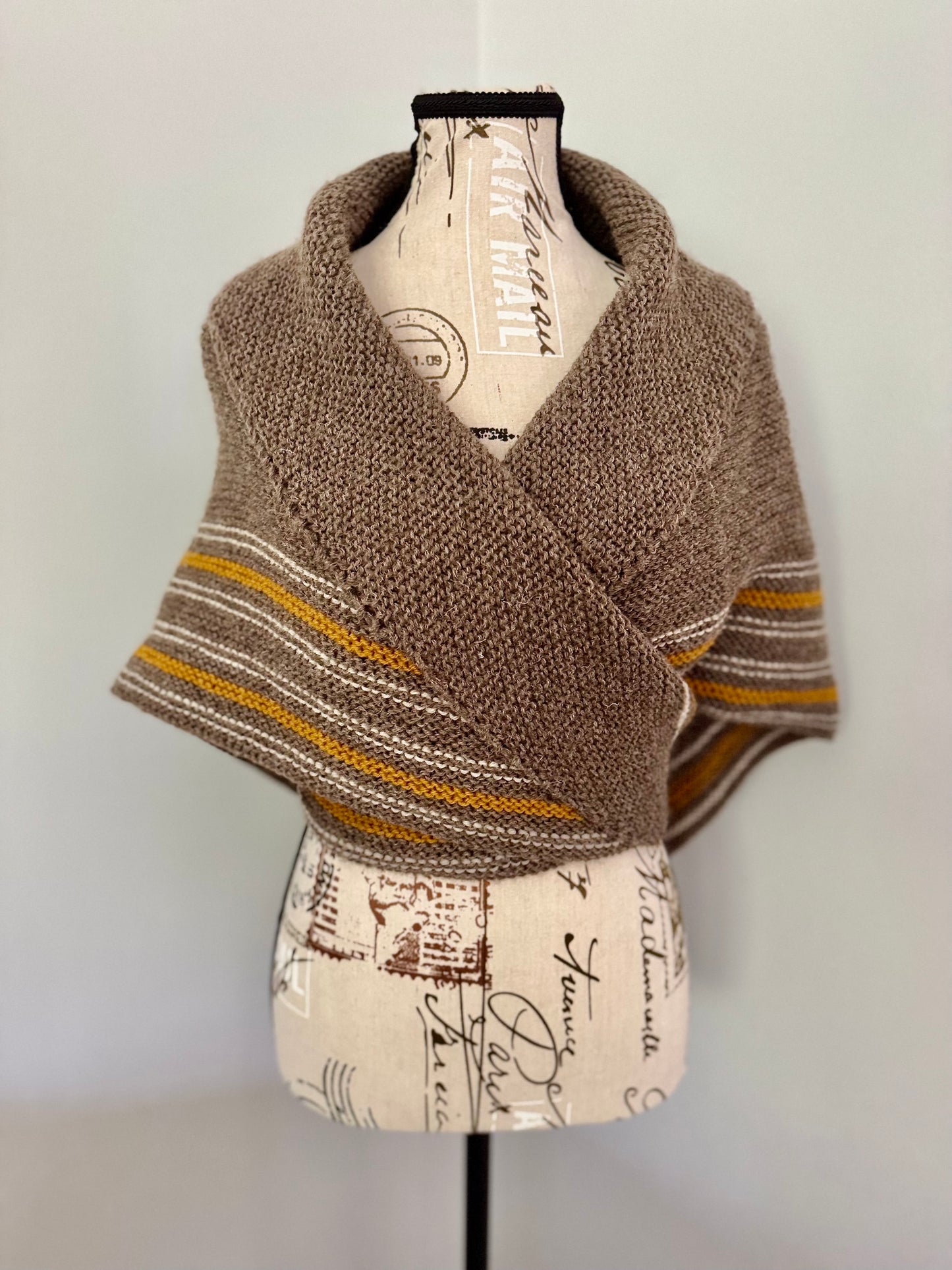 Hand knitted natural brown triangular wrap around shawl featuring stripes and handmade tassles. Custom Commission in a color of your choice.
