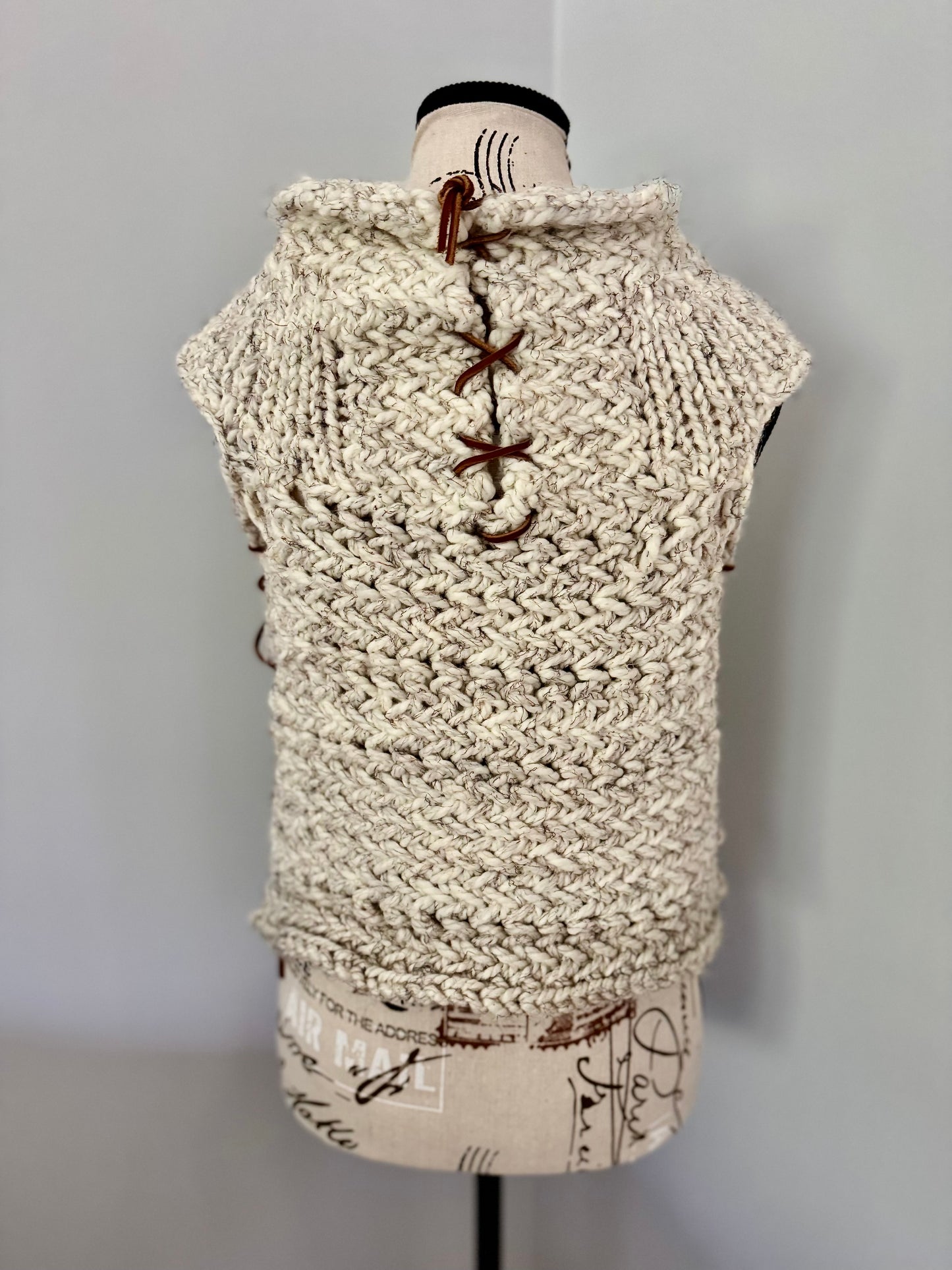 Super bulky and structured hand knitted vest constructed in a herringbone stitch featuring leather lace accents. Custom commission this piece in the color of your choice and in cropped or regular length.