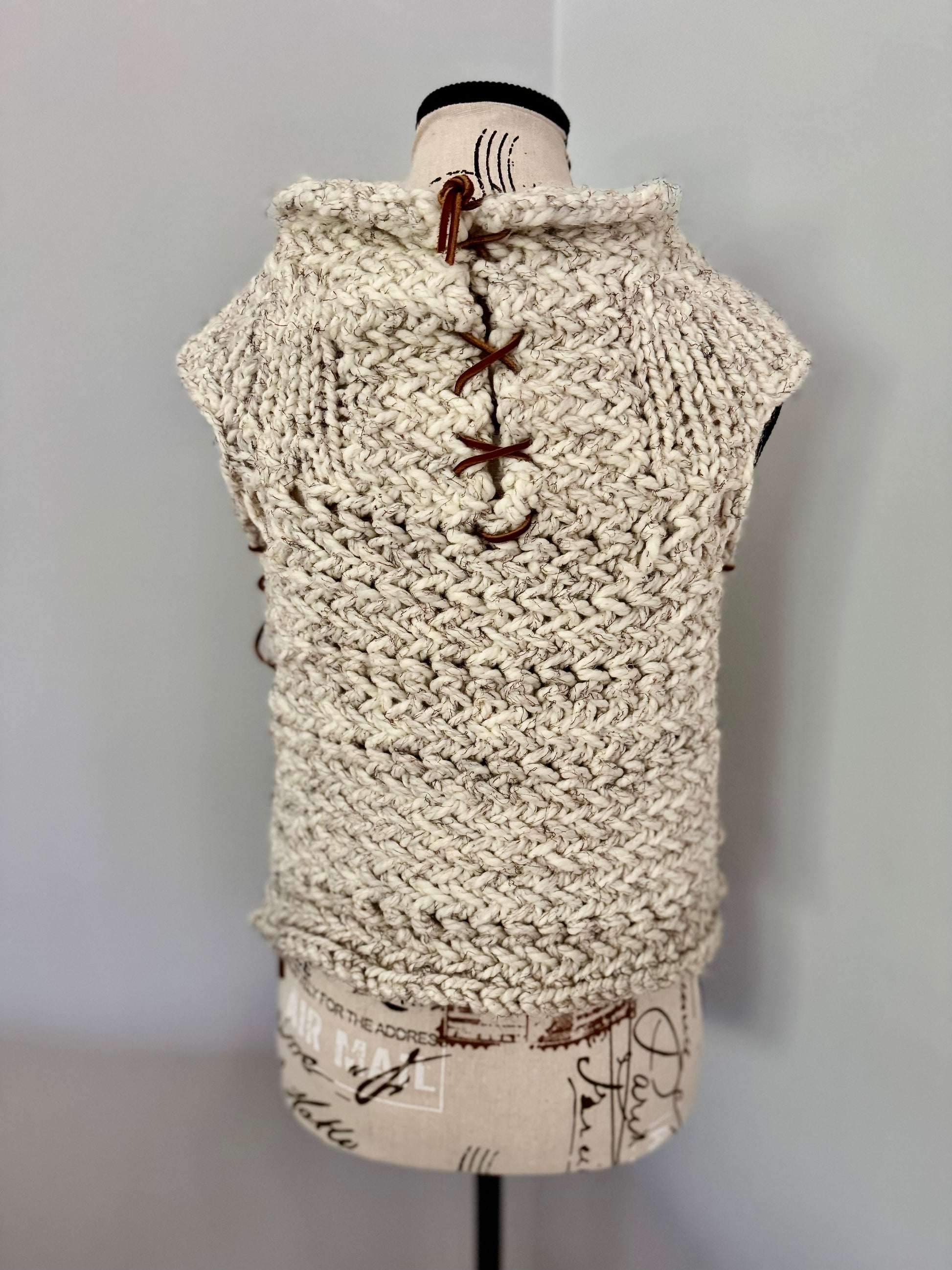 Super bulky and structured hand knitted vest constructed in a herringbone stitch featuring leather lace accents. Custom commission this piece in the color of your choice and in cropped or regular length.