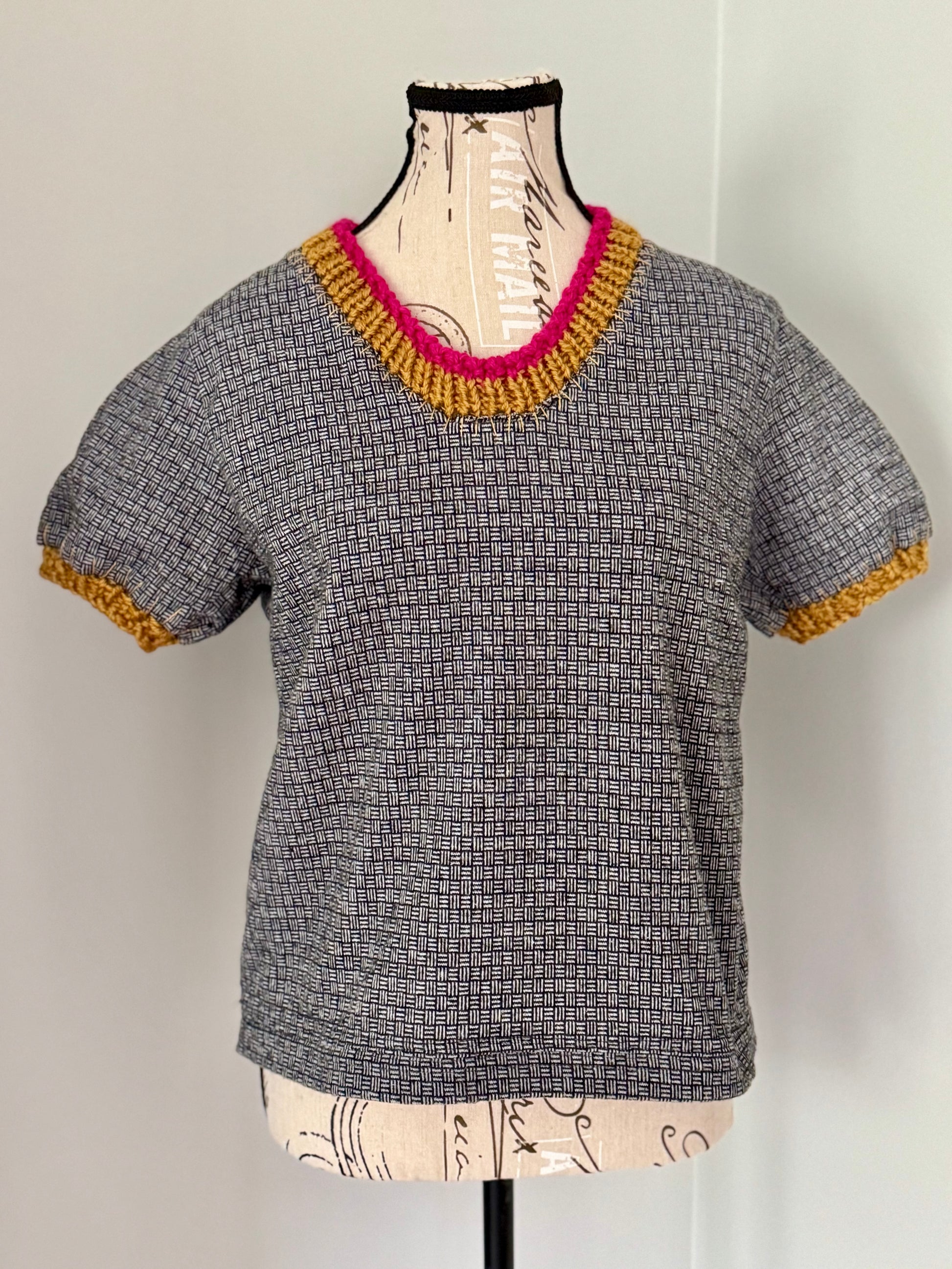 Upcycled black and white merino wool shirt trimmed with gold and magenta hand knitted stitch work.
