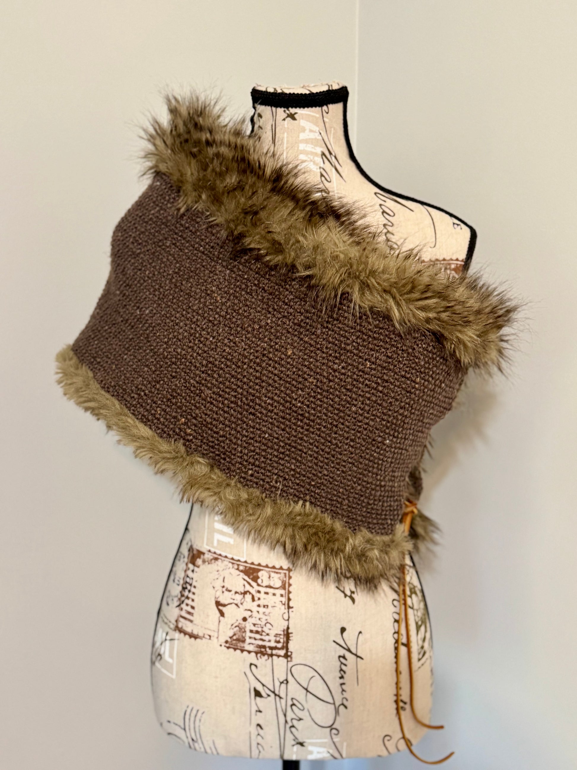 Brown knitted vest with faux fur trim and leather lacing on a mannequin against a plain background